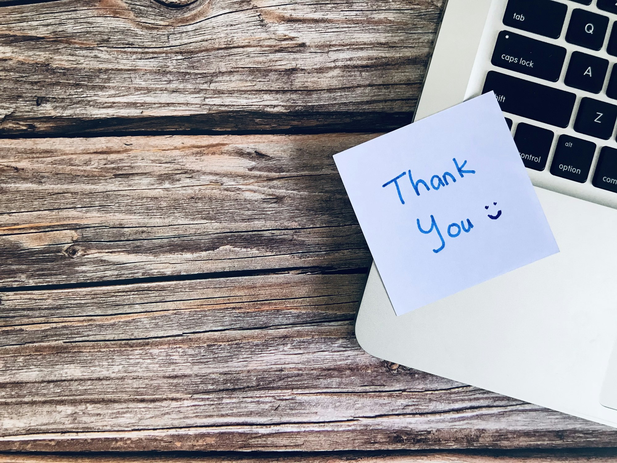 thank you note with a laptop on a wooden table 30